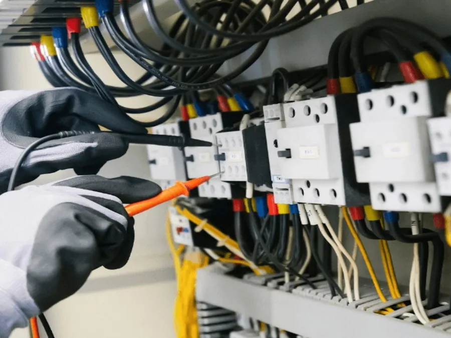 Electrician testing electrical panel wiring